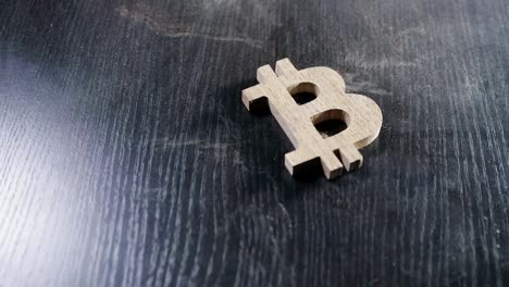 the-wooden-bitcoin-symbol-lies-on-a-dusty-table