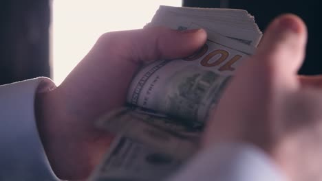 Caucasian-Business-Owner-Counting-One-Hundred-Dollars-Bills-in-His-Hands