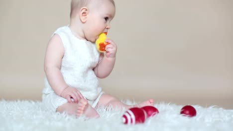 Niedlichen-kleinen-Kleinkind-Baby-jungen-spielen-mit-bunten-Ostereiern-und-kleinen-Zierenten,-isoliert-erschossen,-Beige-Hintergrund