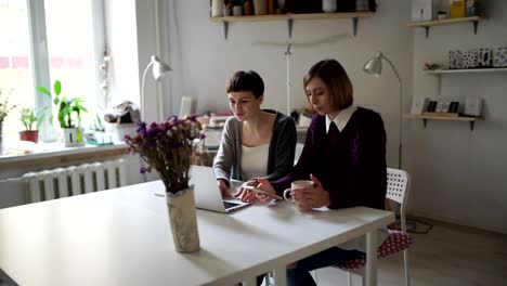 Dos-estudiantes-de-la-mujer-en-la-mesa-con-notebook-para-aprendizaje-en-línea-en-casa