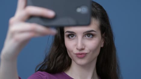 Cute-girl-taking-selfies-with-her-smartphone