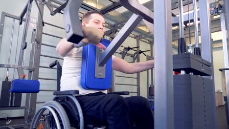 Disabled-man-does-strengths-exercises-for-back-on-training-apparatus.