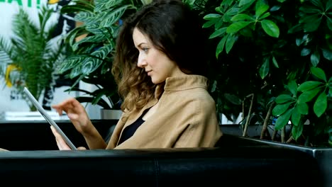 Businesswoman-uses-a-tablet-in-the-business-center