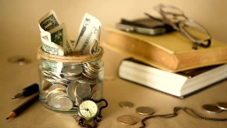 Books-with-glass-penny-jar-filled-with-coins-and-banknotes.-Tuition-or-education-financing-concept.-Scholarship-money.