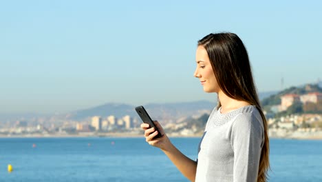 Glückliche-Frau-Telefonieren-am-Strand