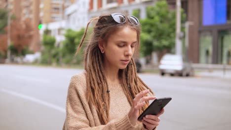 chica-hipster-mensajería-móvil-al-aire-libre