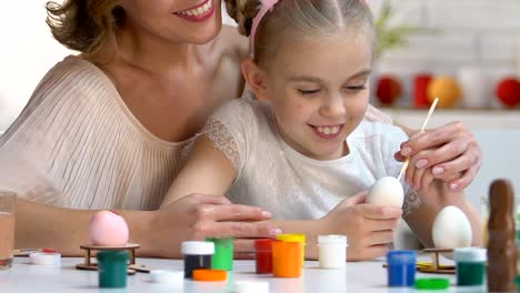 Amorosa-madre-enseñanza-hija-zurda-para-decorar-huevos-de-Pascua-con-pintura