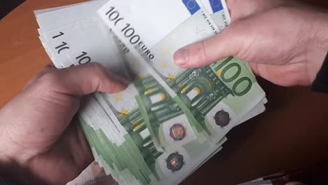 Man-Counting-100-Euro-Banknotes