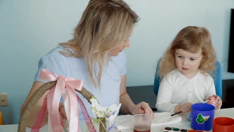 Mother-and-her-little-daughter-painting-Easter-eggs