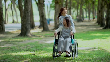 Bonita-hija-adolescente-y-madre-en-silla-de-ruedas-en-el-Parque