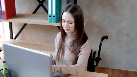 Behinderte-junge-Frau-arbeitet-mit-Laptop-im-Büro