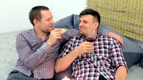 Men-gay-relax-flirting-each-other-and-drinking-a-red-wine-hugging-and-eating.