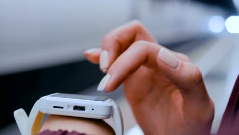 Mujer-usando-reloj-inteligente-blanco-en-la-plataforma-del-metro