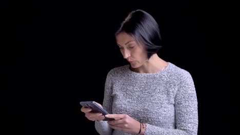 Closeup-portrait-of-young-beautiful-caucasian-female-with-short-black-hair-browsing-on-the-phone-and-reacting-to-social-media-posts