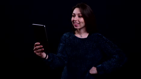 Closeup-portrait-of-adult-beautiful-caucasian-brunette-female-having-a-video-call-on-the-tablet-with-background-isolated-on-black