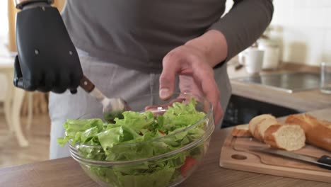 Behinderter-Mann-mit-bionischem-Unterarm-Mischen-Gemüsesalat-in-Schüssel