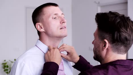 Gay-man-help-his-partner-putting-on-tie-for-job-interview.-Talking.