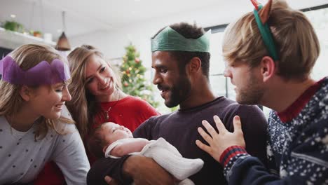 Homosexuell-männliche-paar-mit-adoptierten-Baby-Tochter-feiert-erste-Weihnachten-mit-Freunden