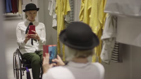 Happy-Woman-in-Wheelchair-Taking-Selfie-at-Clothing-Store