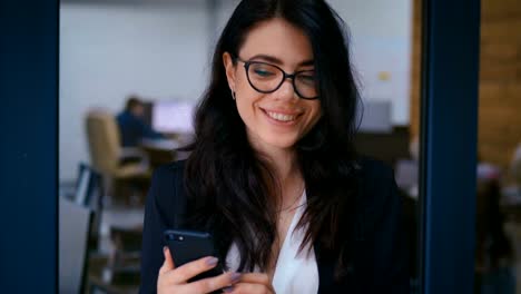 Porträt-der-schönen-jungen-Frau-mit-Smartphone-im-Büro.-Business-Lady-in-formalen-tragen-Kleid-Typing-Nachrichten-auf-ihrem-Handy.