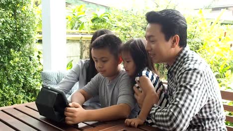 asia-family-looking-tablet-happy-together