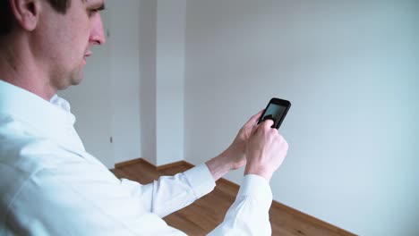 Man-Photographing-Chair-in-Empty-Apartment