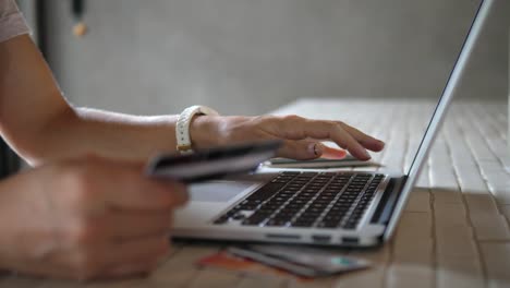 Close-Up-Of-Woman-Shopping-Online-Using-Laptop-With-Credit-Card