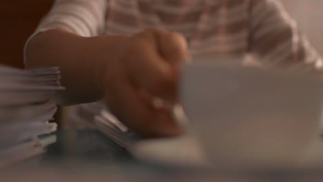 Businesswoman-using-smart-phone-on-the-working-desk-and-drinking-a-cup-of-coffee.