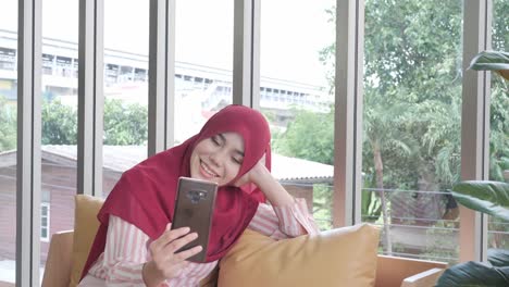 Happy-muslim-woman-using-smartphone-for-video-call-in-home.