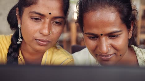 Two-women-chilling-sipping-drinks-using-technology-in-cafe