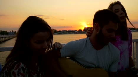 Hermoso-grupo-de-jóvenes-de-adolescentes-cantando-alegremente-en-la-playa