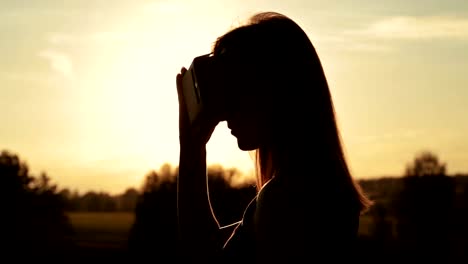 Woman-uses-a-virtual-reality-glasses-in-the-forest-at-sunset