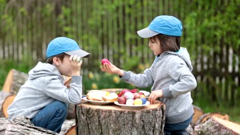 Two-children,-boy-brothers,-having-fun-with-easter-eggs-in-the-park