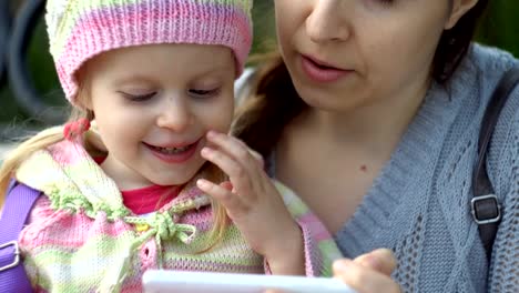 Mother-and-daughter-using-phone-on-outside-a-cool-evening