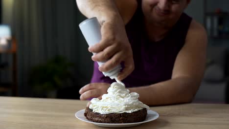 Corpulent-man-decorating-chocolate-cake-with-whipped-cream,-unhealthy-food