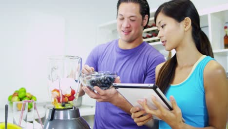 Happy-Asian-Chinese-couple-making-organic-fruit-drink