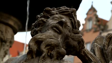 Brunnen-mit-alten-Skulpturen-gegen-Stadtplatz,-historische-Innenstadt,-Tourismus