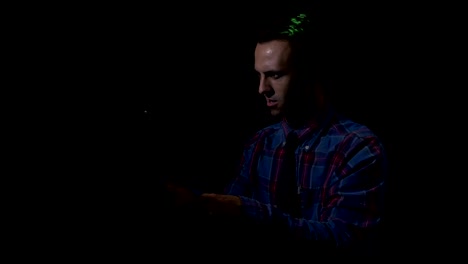 Male-hacker-sitting-in-a-dark-room-in-front-the-computer-and-attacking-corporate-servers-to-steal-bitcoin-currency