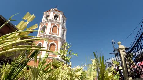 Menschen-Welle-Kokospalme-verlässt-am-Palmsonntag-Feier.-Das-fest-erinnert-an-den-triumphalen-Einzug-Jesu-in-Jerusalem.-Kirchturm-Hintergrund