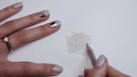 Female-hand-shades-with-pencil-on-paper-and-appears-image-of-bitcoin