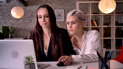 Two-young-pretty-lesbians-working-in-modern-office,-woman-flirting-with-woman,-touching-her-hand,-seductive-and-sexy