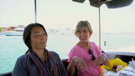 slow-motion-older-caucasian-and-asian-women-being-silly-and-having-fun-on-a-boat