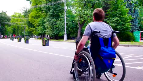 Desactiva-el-joven-hombre-caminando-en-el-parque-en-silla-de-ruedas