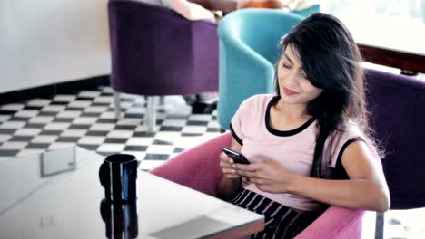 A-beautiful-young-woman-with-long-black-hair-sitting-in-coffee-shop