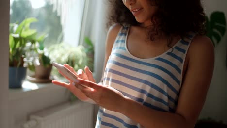 Young-woman-typing-on-mobile-phone-at-home.