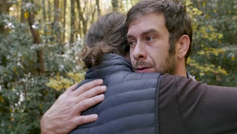 Two-young-men-hugging-outside-in-a-park-consoling-each-other-during-the-day