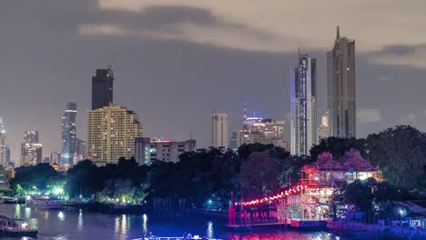 Timelapse-skyscrapers-in-nightfall-downtown-and-river-at-foreground