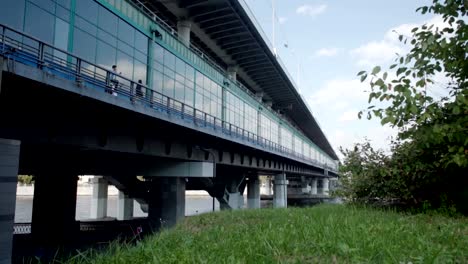 Panorama-of-a-glass-bridge-with-a-passing-train-inside