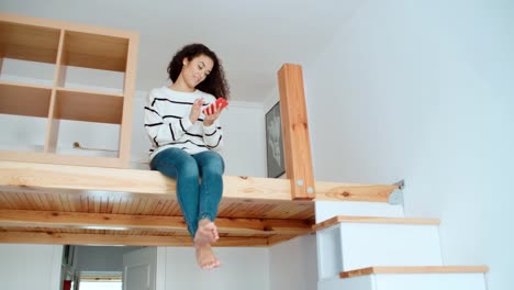 Charmante-junge-Frau,-die-in-einer-modernen,-stilvollen-Wohnung-telefoniert.