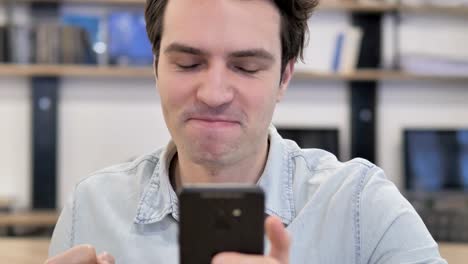 Portrait-of-Creative-Man-Excited-for-Success-while-Using-Smartphon